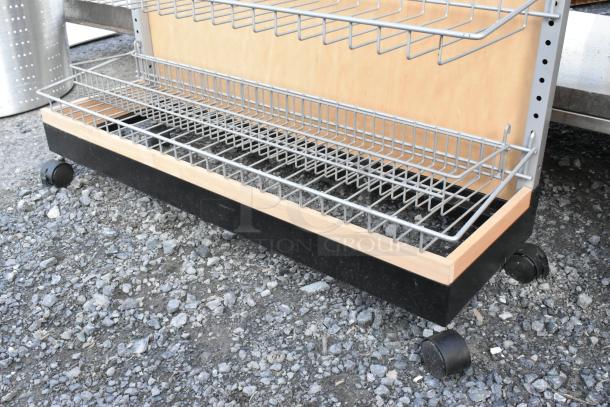 Merchandising rack on casters with metal wire shelves and wooden base; good condition, ideal for retail display.