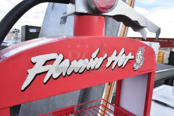 Metal red shelving unit with "Flamin Hot" branding and decorative fire extinguisher top, in good condition.