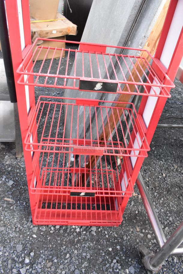 Red metal shelving unit with three wire shelves and decorative fire extinguisher top. Good condition, urban industrial style.