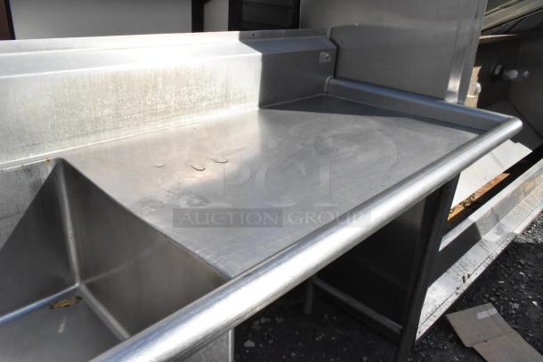 Stainless steel 3 bay sink with dual drain boards, faucet, and handles. Features a durable, spacious design, ideal for commercial use.