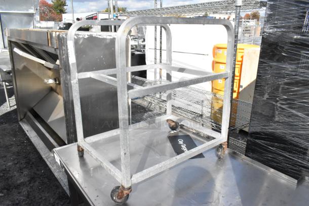 Metal pan transport rack on commercial casters, sturdy frame, used condition. Ideal for kitchen or catering use.