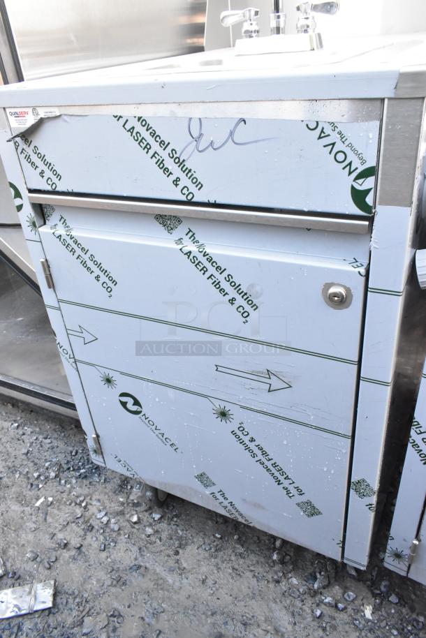 QualServ stainless steel portable sink with commercial casters, scratch and dent condition, protective film visible.