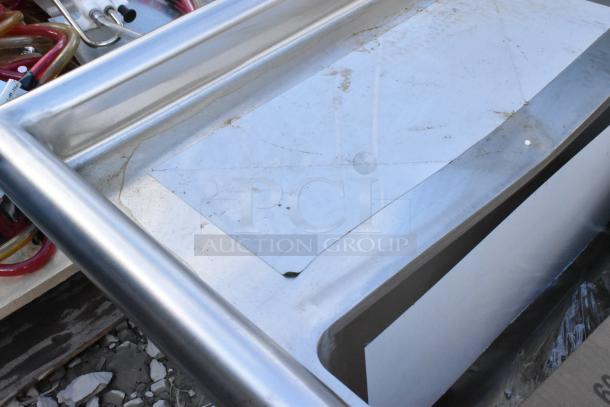 Brand new Regency 600S31220212 three-compartment commercial sink, 16-gauge stainless steel, galvanized legs, visible scratches.