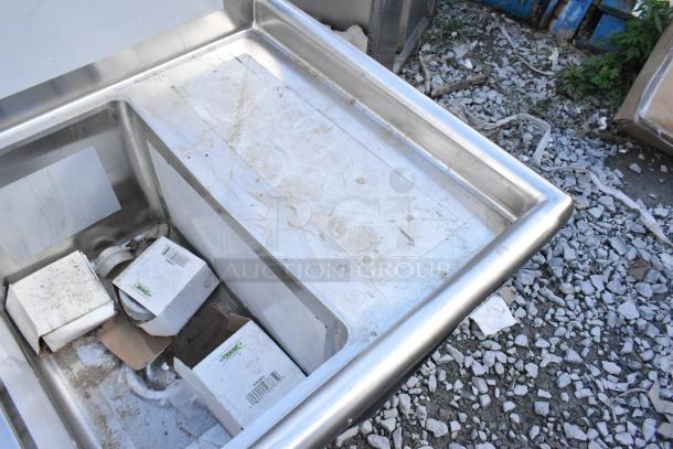 Regency 600S31220212 three-compartment stainless steel sink with galvanized legs, scratches and dents visible, includes 2 drainboards.