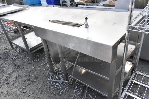 Stainless steel commercial soda station with faucet, under shelves, and a top drain. Used condition, sturdy construction.