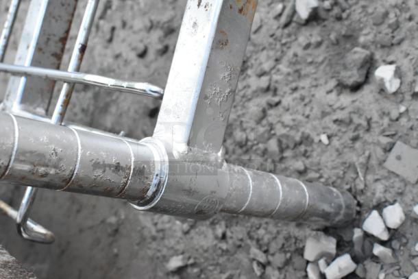 Metro chrome finish 4-tier wire shelving unit, metal framework detail, visible rust, buyer to dismantle before shipping.