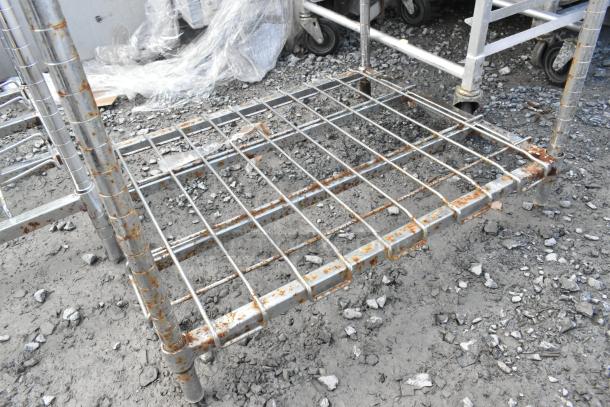 Metro chrome 5-tier wire shelving unit with rust, requiring dismantling. Review freight charges.