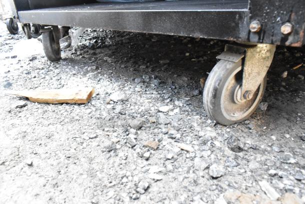 Vulcan 1013776 bakery display rack with metal baskets on commercial casters. Image shows the caster wheel condition.