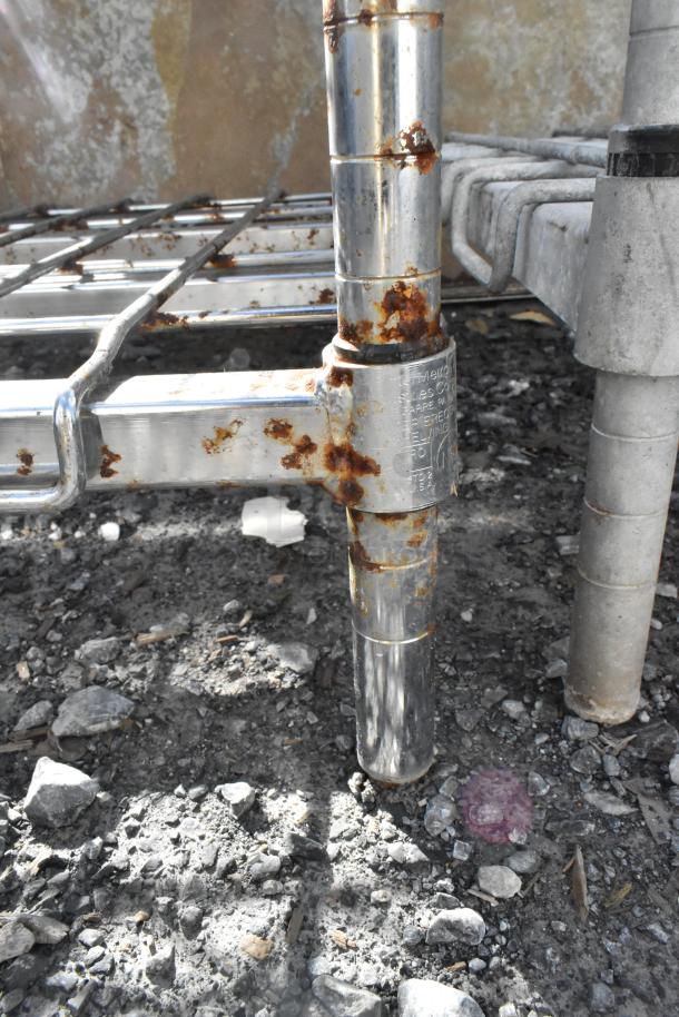 Metro 5-tier wire shelving unit with chrome finish, visible rust on joints, buyer must dismantle for shipping.