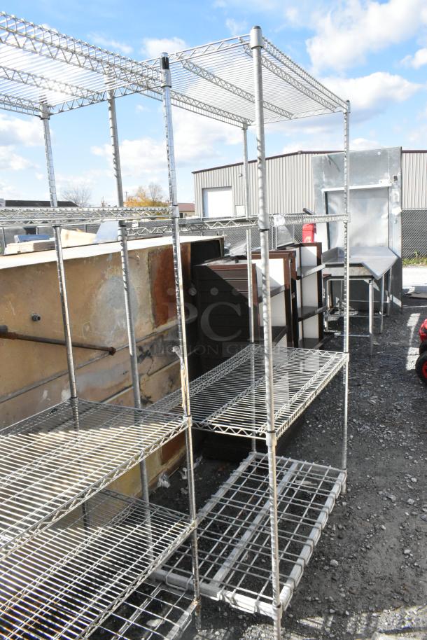 Metro Chrome Finish 4 Tier Wire Shelving Unit, outdoor setting. Condition appears used. Buyer must dismantle.