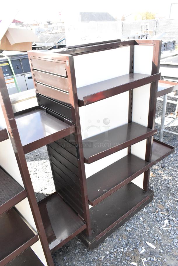 Two metal merchandising display racks with four shelves each, dark brown with white backing, visible wear, sturdy construction.