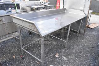 Stainless steel table with raised edges, showing light rust and wear on legs. Ideal for industrial or kitchen use.