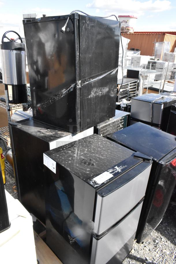 Five mini coolers, models MS553614756001, Magic Chef HMBR350BE1, Hisense RT32D6ASE, WMR04GAVBBB, QBD DC6LP, stacked outdoors.