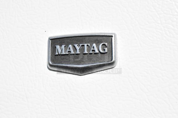 Maytag M1TXEGMYW01 cooler/freezer badge on white surface, indicating brand identity.