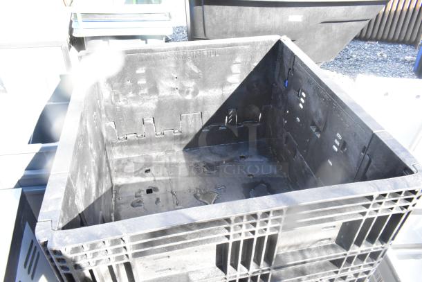 Stacked Orbis black poly bins in used condition, sturdy with visible slots, ideal for storage. Auction includes five bins.