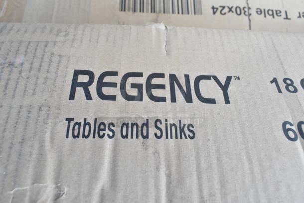 Cardboard box labeled "Regency Tables and Sinks," indicating unassembled stainless steel equipment and pan racks inside.