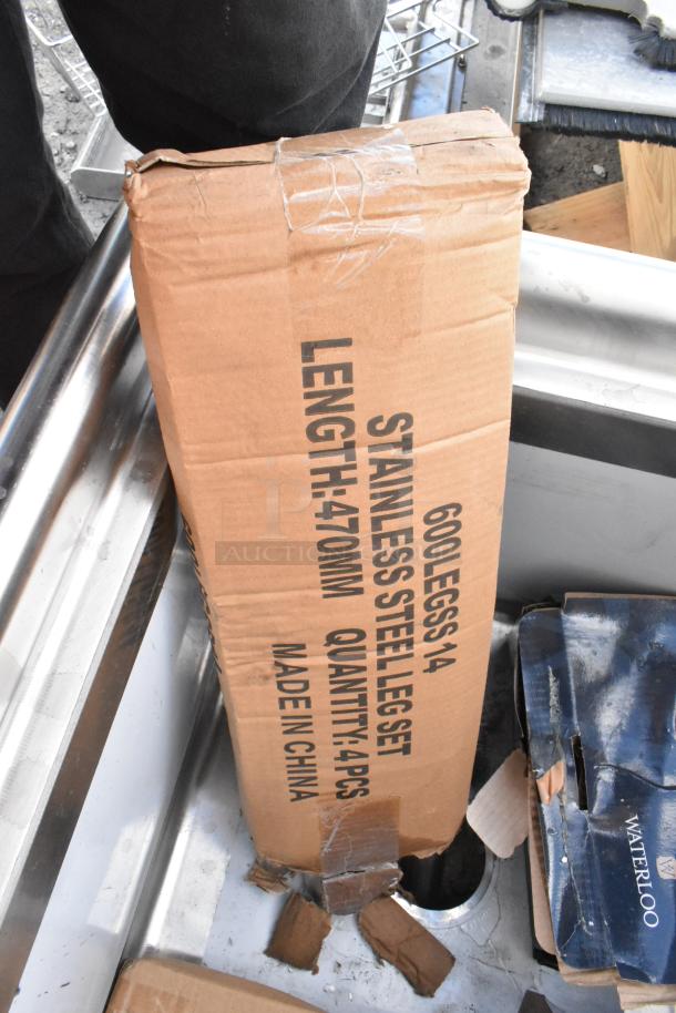 BRAND NEW SCRATCH AND DENT Regency 600S11818 stainless steel single bay sink, visible packaging damage, labels show "600 Legs 1/4, Stainless Steel Leg Set, Length: 470mm, Quantity: 4pcs, Made in China."