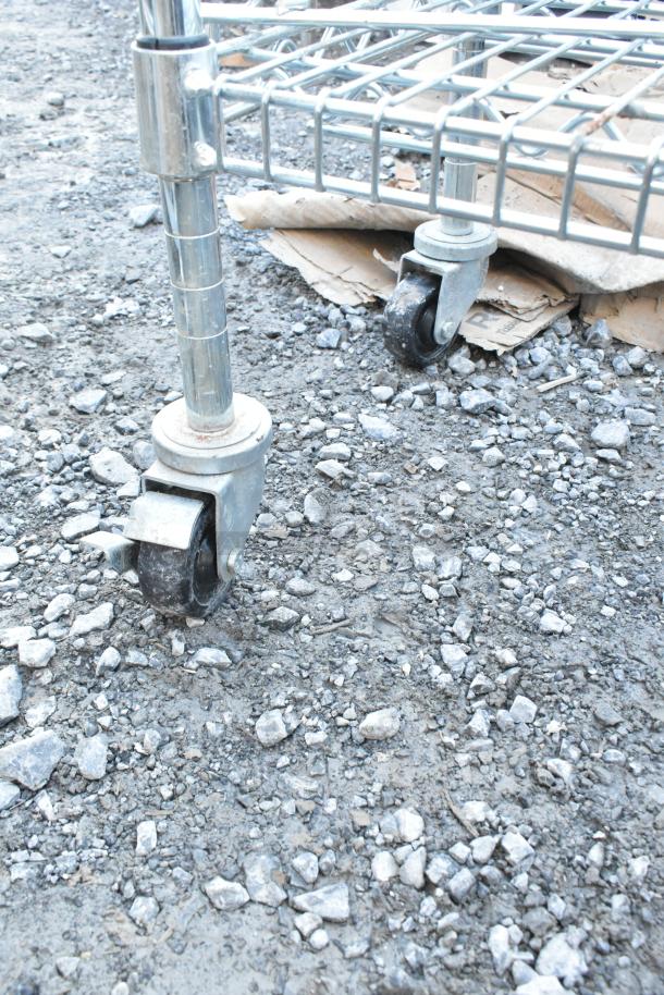 Chrome finish wire shelving unit on commercial casters, single tier, requires dismantling for shipping.