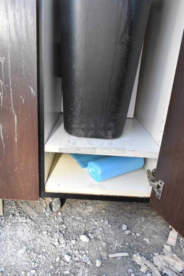 Trash can shell with deposit holes, featuring doors on commercial casters. Includes black bin and blue trash bags, condition worn.