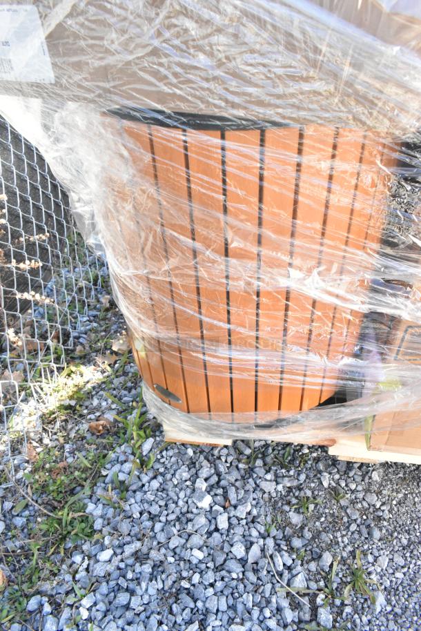 Plastic-wrapped pallet of assorted household items, including wood slat decor, on gravel; part of auction lot.