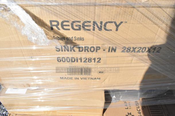 Cardboard box labeled "Regency Tables and Sinks, Sink Drop-In 28x20x12, 600DI12812, Made in Vietnam," wrapped in plastic.