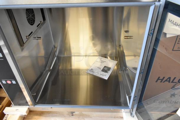 Brand new Alto Shaam AR-7EVH stainless steel commercial rotisserie oven, 240V, 1 phase, with manual visible inside.