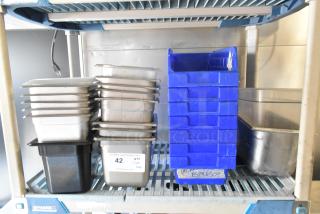Tier lot of various items including stainless steel and poly drop-in bins stacked on metal shelving.