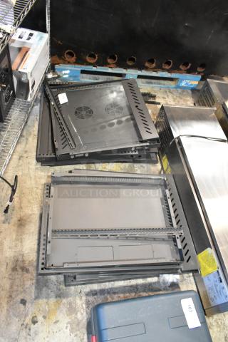Lot of black metal panels with perforated edges, multiple ventilation slots, and fan cutouts. Some panels feature labels and minor surface wear. Ideal for server racks or custom installations.