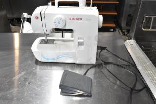 Singer 1304 countertop sewing machine with foot pedal, clean, white with blue accents, in good condition.