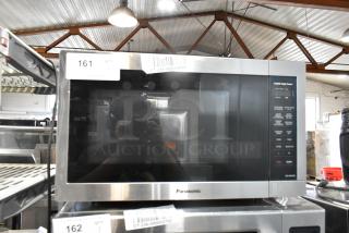 Panasonic metal countertop microwave oven, stainless steel finish, in good condition, includes plate, model details visible.