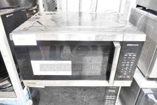 Toshiba WSI-EM22AST metal countertop microwave oven with plate, 120 volts, 1 phase; visible wear and control panel on side.