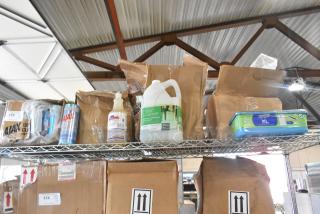 Tier lot on metal shelf with Diversey grill cleaner, Ajax bleach cleanser, and Swiffer XL pads. Condition varies.