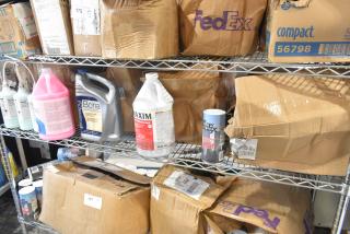Tiered lot on shelves with Rubbermaid lotion, Boardwalk soap refill, Bona floor cleaner, Office Snax sugar. Boxes are worn.