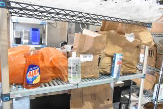 Tiered lot with Ajax liquid soap, EyeSaline eyewash, and Ajax bleach cleanser on metal shelving, includes cardboard packaging.