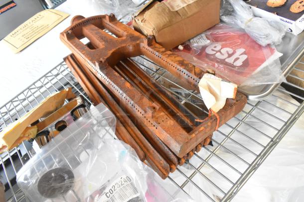 Tier lot of various items, including HP Bright White Inkjet Paper, rusted metal parts, UPR6GE plates, on a metal rack.