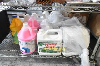 Tier lot of cleaning supplies, including Spray Nine Degreaser, Boardwalk Hand Soap, Clorox Cleaner on metal shelf.