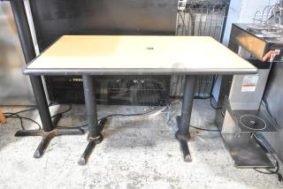 Dining height table with wood pattern top on two black metal bases, in good condition. Ideal for commercial or home use.