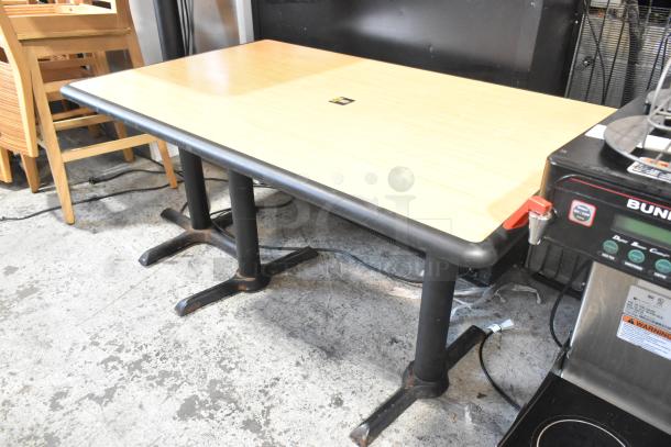 Wood pattern dining height table with two black metal bases, in good condition, ideal for versatile seating arrangements.
