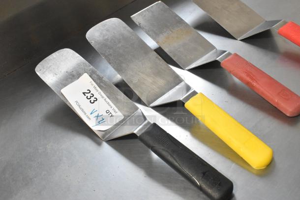Four metal spatulas with different colored handles. Auction label reads "233, Qty 4, VX4." In used condition.