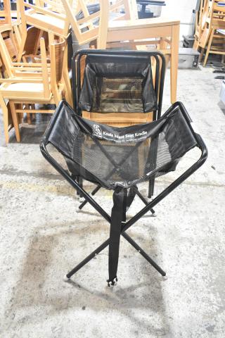 Two Koala Kare Infant Seat Kradles, black mesh and metal frames, sturdy condition, with branding on fabric.