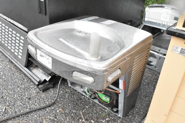 Two metal wall-mounted water fountains in used condition, with visible labels and fittings for installation.