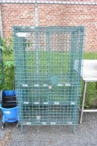 Green 4-tier wire shelving unit with liquor cage, padlocked. Used condition. Buyer must handle dismantling and shipping.