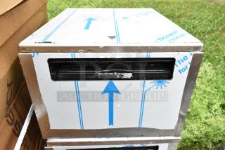 Brand new stainless steel drawer with protective film showing minor scratches and dents. Blue arrows on packaging.