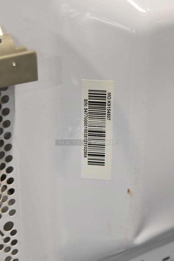 Toshiba metal countertop microwave oven with plate. Barcode label with serial number visible. 120 Volts, 1 Phase.