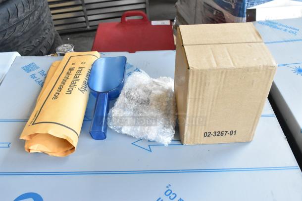 New Scotsman CU0715MA-1A medium cube ice machine packaging, includes a blue scoop, installation manual, and sealed parts.