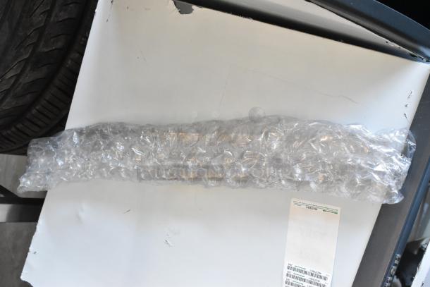 Bubble-wrapped item with visible shipping label on white surface; part of a Scotsman CU0715MA-1A ice machine.