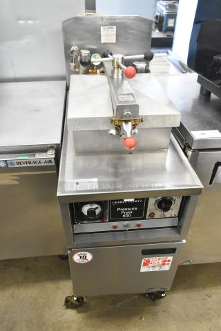 Henny Penny 600 stainless steel pressure fryer on casters, natural gas, 80,000 BTU. Front dial, labels visible. Good condition.