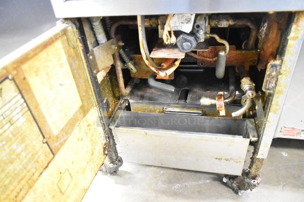 Henny Penny 600 stainless steel pressure fryer, natural gas, 80,000 BTU, on commercial casters, shows interior condition.