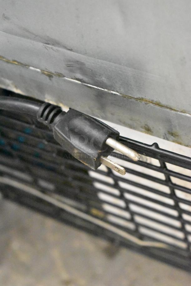 Power cord of Dukers DUC29R undercounter cooler, showing 115V plug and rear grille detail.
