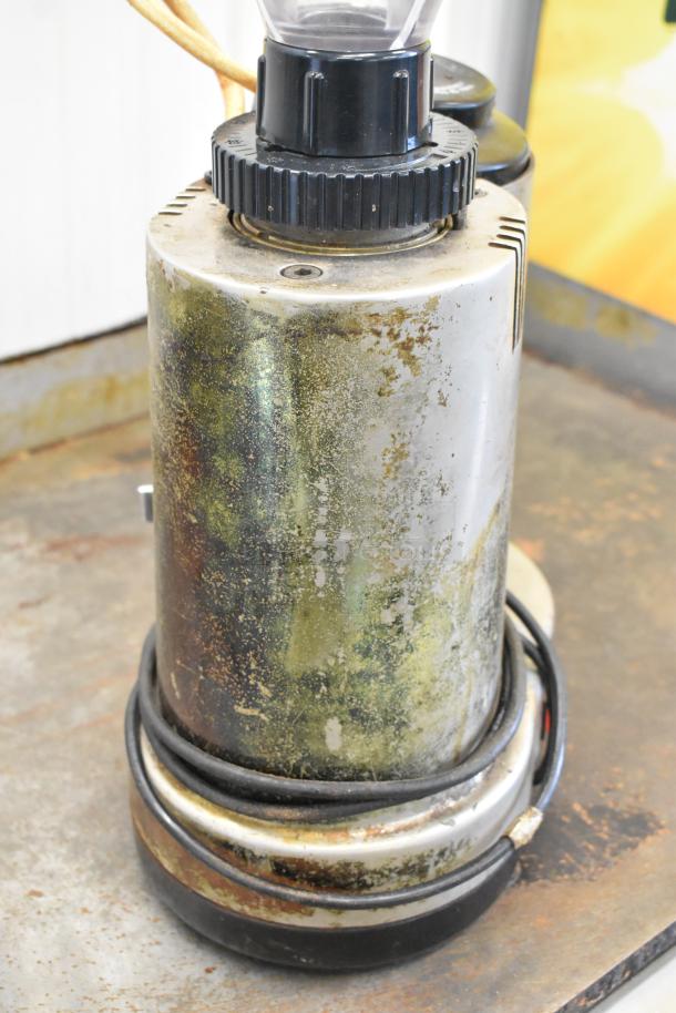Metal commercial countertop espresso bean grinder, 115 volts, 1 phase, visible wear and patina, cord coiled at base.